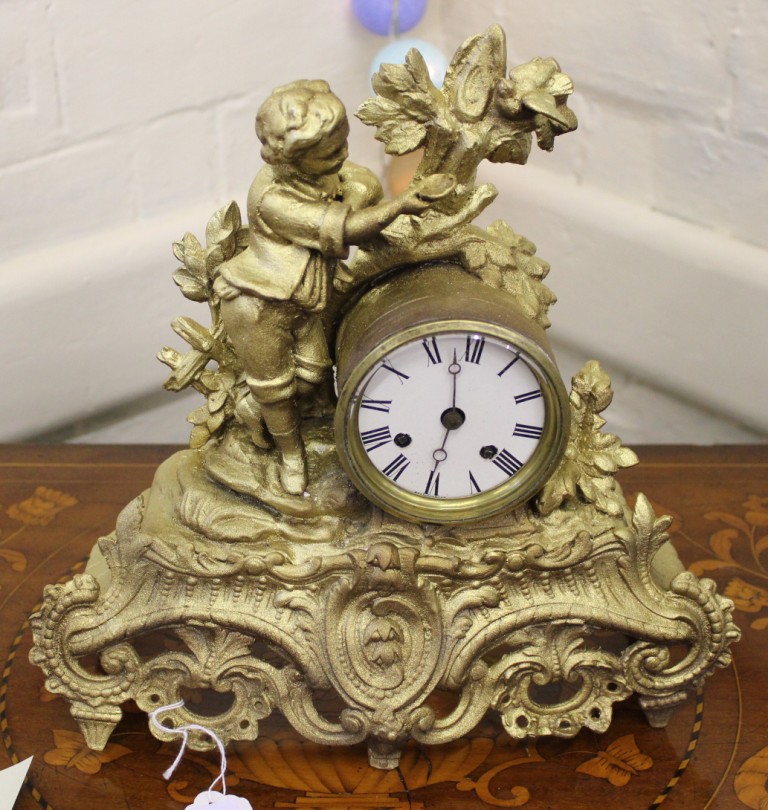 A 19th century French-style ormolu mantle clock with elaborate carving and profuse fret work,