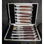 A cased set of six steak knives and forks