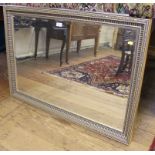 A profusely carved gilt framed wall mirror of oblong form with bevelled plate, 100cm x 70cm