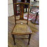 A 1920's beech bedroom chair with cane seat