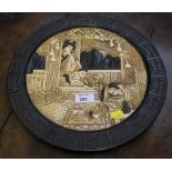 A Bretby wall plaque decorated in the Japanese style with figures in a domestic setting, 34cm