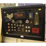 A framed and glazed display of Royal Military Police insignia