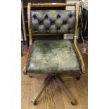 A 1970's swivel office chair with green leather upholstery