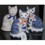 A pair of Rye pottery cats decorated in blue and pink, and another with floral decoration, 14cm high