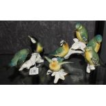 A Karl Ens German porcelain figural group of four birds on a branch, a similar group of two birds