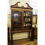 A George III mahogany bookcase cabinet with swanneck pediment and inlaid imitation fluted friezetwin