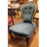 A Victorian nursing chair with carved back and green upholstery