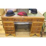 A pedestal desk with green leather top, three top drawers, three left drawers and cupboard to right,