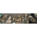 A selection of silver plated wares including small trays, tongs, cutlery and knife rests