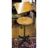 An oak music stand with brass stem and fittings on cast iron foot 100cm high