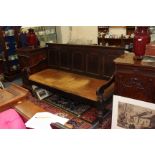 AN ANTIQUE OAK SETTLE with a panelled back and an inset dralon upholstered seat and turned front