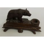 A LATE 19TH TO EARLY 20TH CENTURY CARVED WALNUT BLACK FOREST PEN STAND surmounted by a carved figure