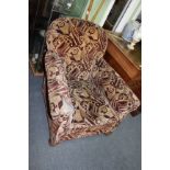 AN EARLY 20TH CENTURY UPHOLSTERED ARMCHAIR with turned front feet and castors 81cm wide