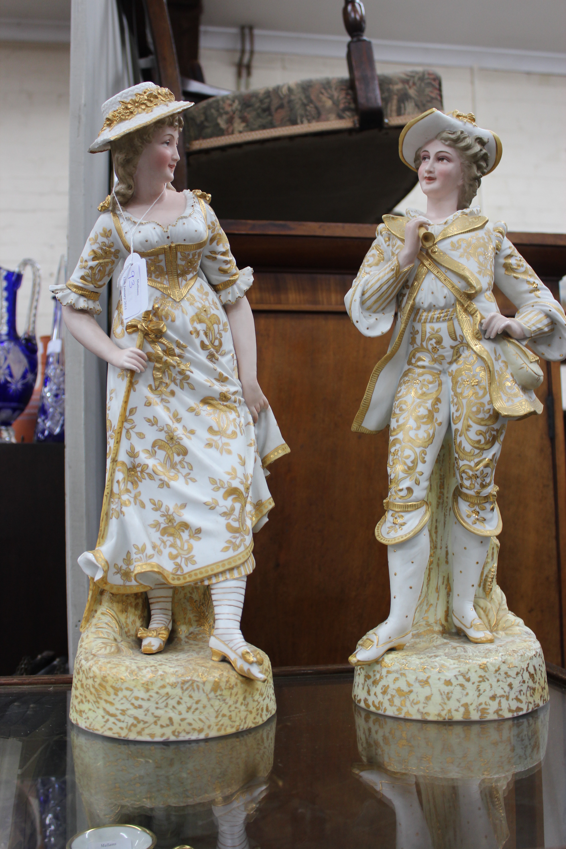 A PAIR OF 20TH CENTURY CONTINENTAL PORCELAIN LARGE FIGURES, a gentleman in a hat with a frilly
