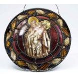 AN ANTIQUE LEADED STAINED GLASS ROUNDEL depicting Joseph of Arimathaeh carrying Jesus from the