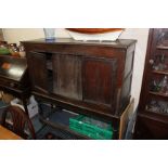 AN ANTIQUE OAK CUPBOARD ON STAND 126cm wide