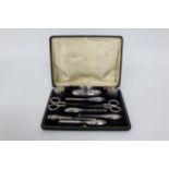 AN EARLY 20TH CENTURY SILVER MOUNTED MANICURE SET, one associated part and all within fitted case