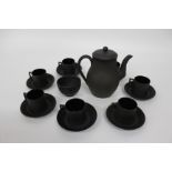 A WEDGEWOOD BLACK BASALT PART COFFEE SET consisting of seven cups and saucers, a coffee pot and a