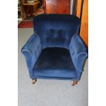 AN EARLY 20TH CENTURY BLUE UPHOLSTERED LOW ARMCHAIR standing on short turned legs 78cm wide