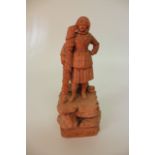 A LATE 19TH/EARLY 20TH CENTURY BRETON TERRACOTTA FIGURE of a woman standing on a rocky outcrop,