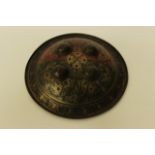 A SMALL CIRCULAR STEEL MIDDLE EASTERN SHIELD engraved with flowers on coloured grounds, the