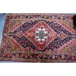 A KASAK STYLE BLUE GROUND RUG with central red ground diamond motif within a multiple banded border,