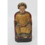 A CARVED GILT GESSO AND PAINTED CHINESE FIGURE OF A SEATED DIGNATORY, 30cm high