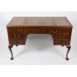 A MAHOGANY WRITING DESK with triple leather inset top and with six drawers around a central kneehole