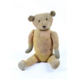 A WELL WORN STRAW FILLED PLUSH TEDDY BEAR with growler 54cm ear to tail