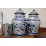 A PAIR OF MID 20th CENTURY BLUE AND WHITE POTTERY VASES with covers, 24cm in height, plus small