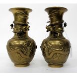 A PAIR OF CHINESE BRASS VASES decorated with dragons, chasing flaming pearls with cast character