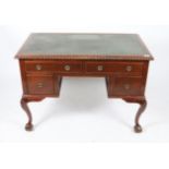 A WRITING DESK with green leatherette inset top, gadrooned edge and four drawers around a central