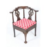 A GEORGIAN STYLE MAHOGANY CORNER CHAIR with pierced vase shaped splats and turned supports to the