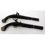 A PAIR OF ANTIQUE PERCUSSION CAP PISTOLS with carved stocks and brass mounts, 41 cm long (2)