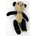 A SMALL EARLY 20TH CENTURY PANDA PLUSH TEDDY BEAR with jointed arms and legs, approximately 14cm