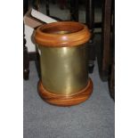 A LARGE WWI BRASS SHELL CASE CONVERTED FOR USE AS A WASTE PAPER BIN with turned hardwood mount and