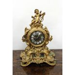 A FRENCH GILT METAL TIMEPIECE the scrolling case surmounted with Putti playing a lyre, the brass