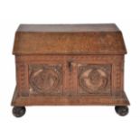 AN ANTIQUE CONTINENTAL OAK COFFER with domed top, cherub carved panels to the front with iron