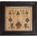 AN 18TH CENTURY MINIATURE NEEDLEWORK SAMPLER with flowers, trees and geometric shapes mounted in