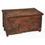 AN ANTIQUE SIX-PLANK COFFER with a leather hinged lid and low arched legs to the side, 63cm wide