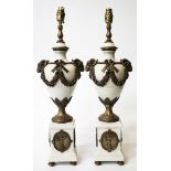 A PAIR OF FRENCH POTTERY TABLE LAMPS with bronzed metal rams head floral swag mounts, standing on