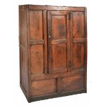 A 17TH/18TH CENTURY OAK CUPBOARD of pegged panelled construction, the single door with wrought