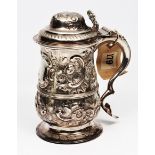 A GEORGE III SILVER LIDDED TANKARD with a domed top, pierced scrolling thumbpiece and  baluster body