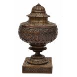 AN ANTIQUE TURNED TREEN LIDDED CHALICE with carved decoration, a turned stem and a square base (AF),