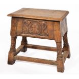 AN ANTIQUE OAK JOINT STOOL, having a lifting hinged lid and carved decoration, 47cm wide