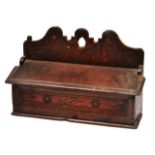 AN EARLY 18TH CENTURY OAK CANDLE BOX, with a shaped back and lifting lid above a moulded front