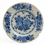 A GEORGE III IRISH DELFTWARE PLATE decorated in cobalt blue with a vase of flowers and lucky symbols