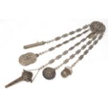 AN ANTIQUE WHITE METAL CHATELAINE with filigree decoration, the suspension boss with Viking head and