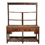 A GEORGE III OAK DRESSER with two shelf plate rack above, the base with three drawers, each with