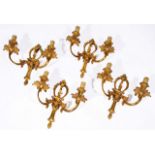 A SET OF FOUR GILT METAL TWO BRANCH WALL LIGHTS with acanthus leaf and scroll decoration, 32.5cm